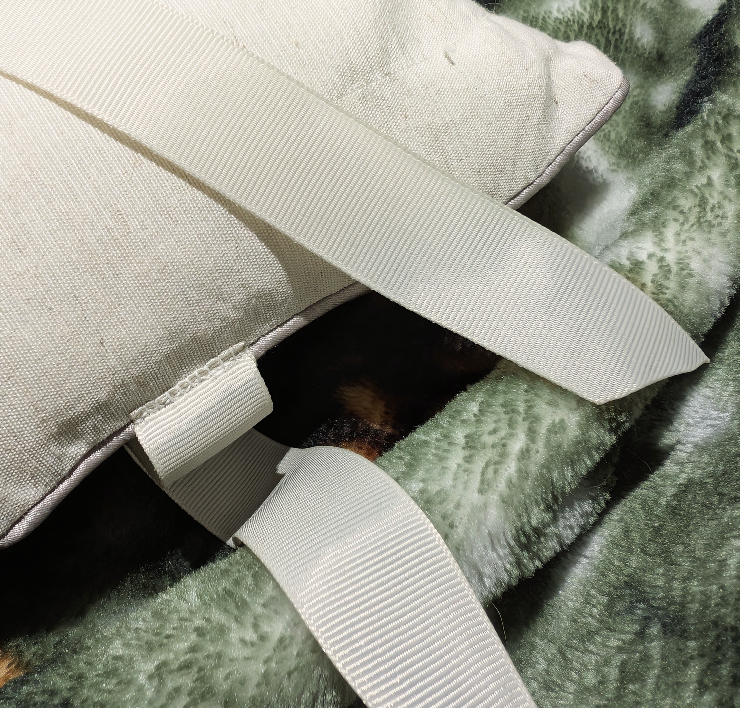 The ribbon sewn onto the pillow.