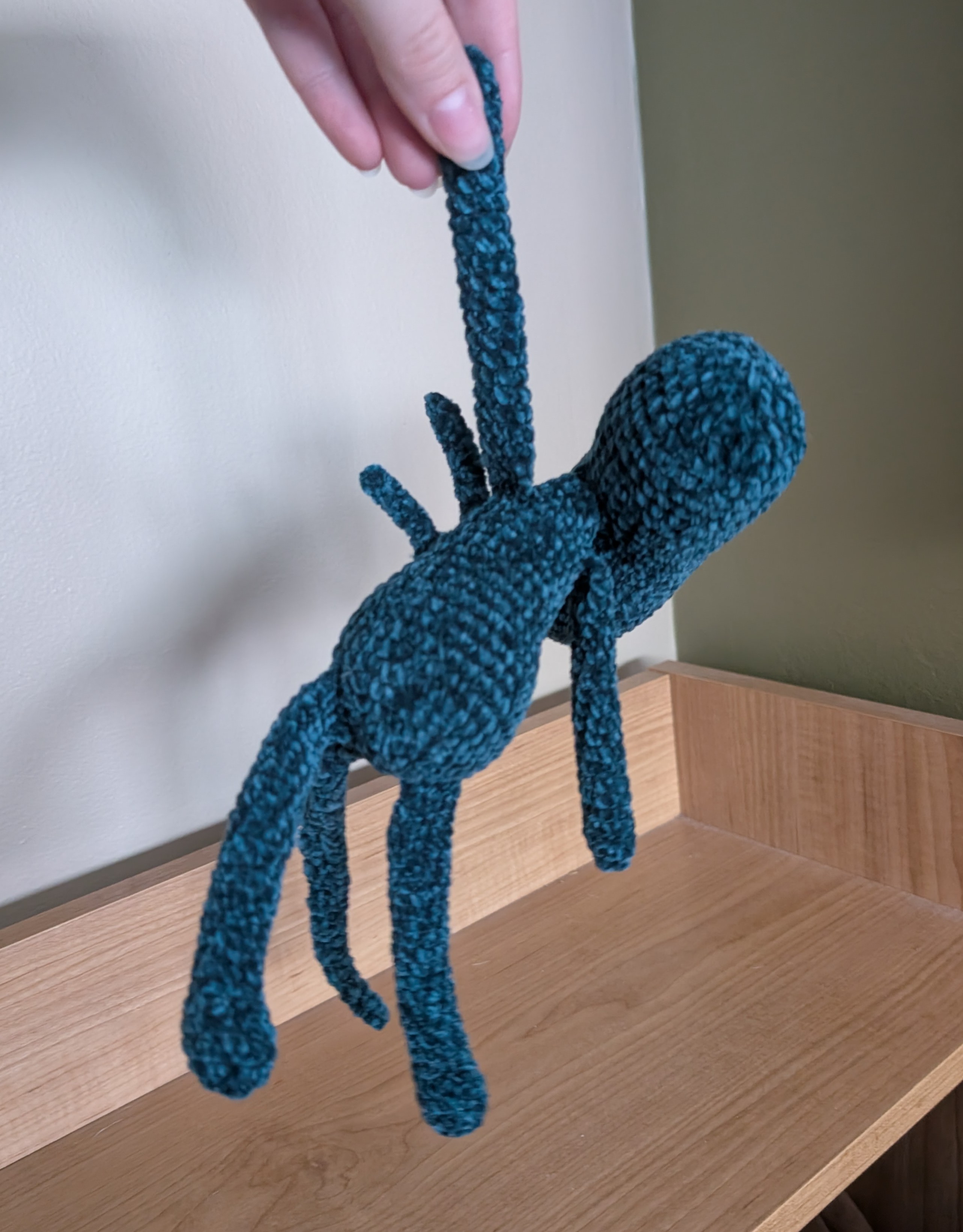 Silly Alien being held up by one arm.